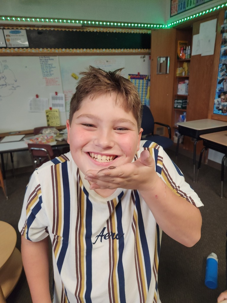 4th graders holding a beetle.