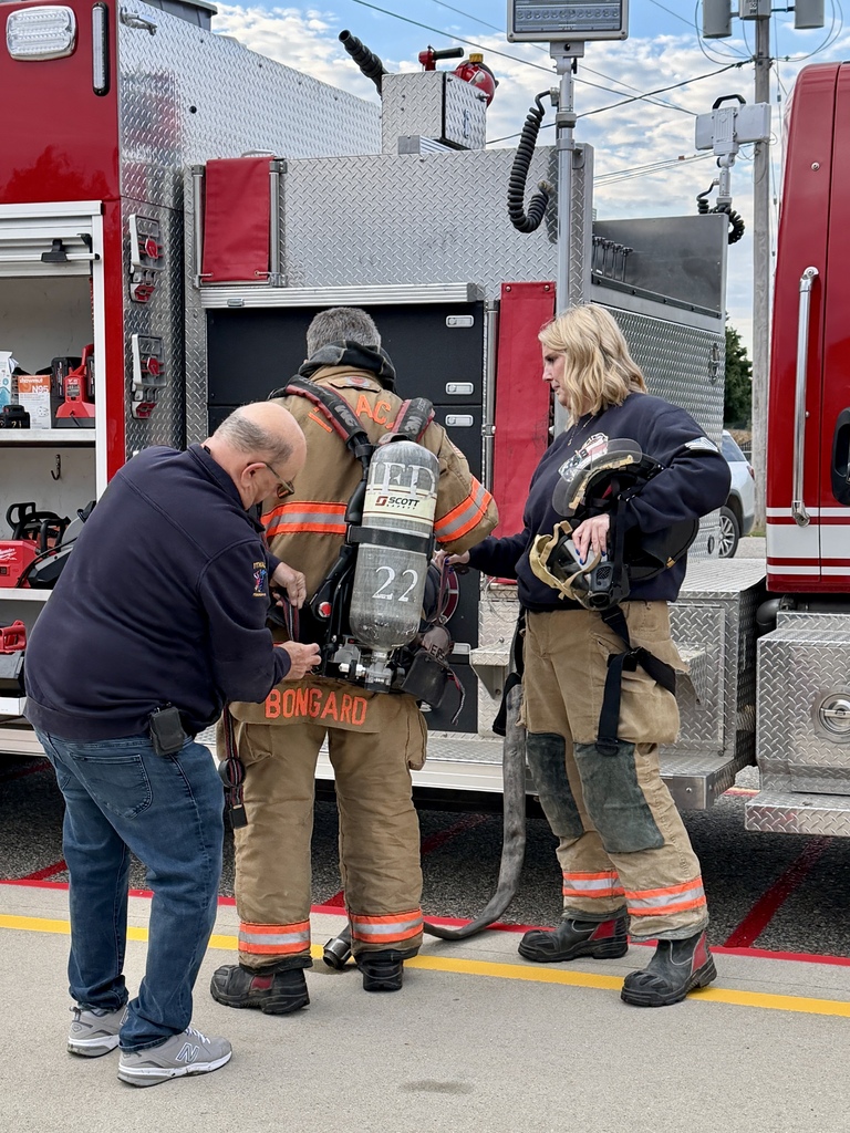Firefighters demonstrating how to put on their equipment.