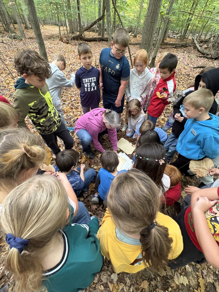 teacher instructing students in the woods