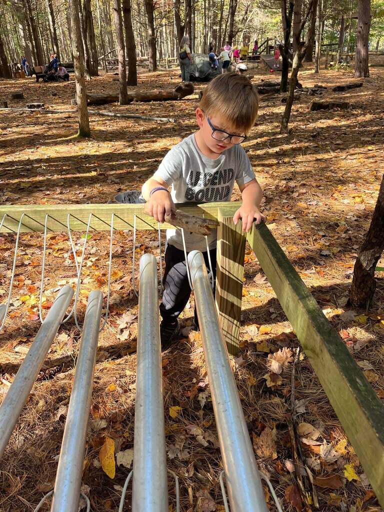 A student plays an outdoor wind chime.