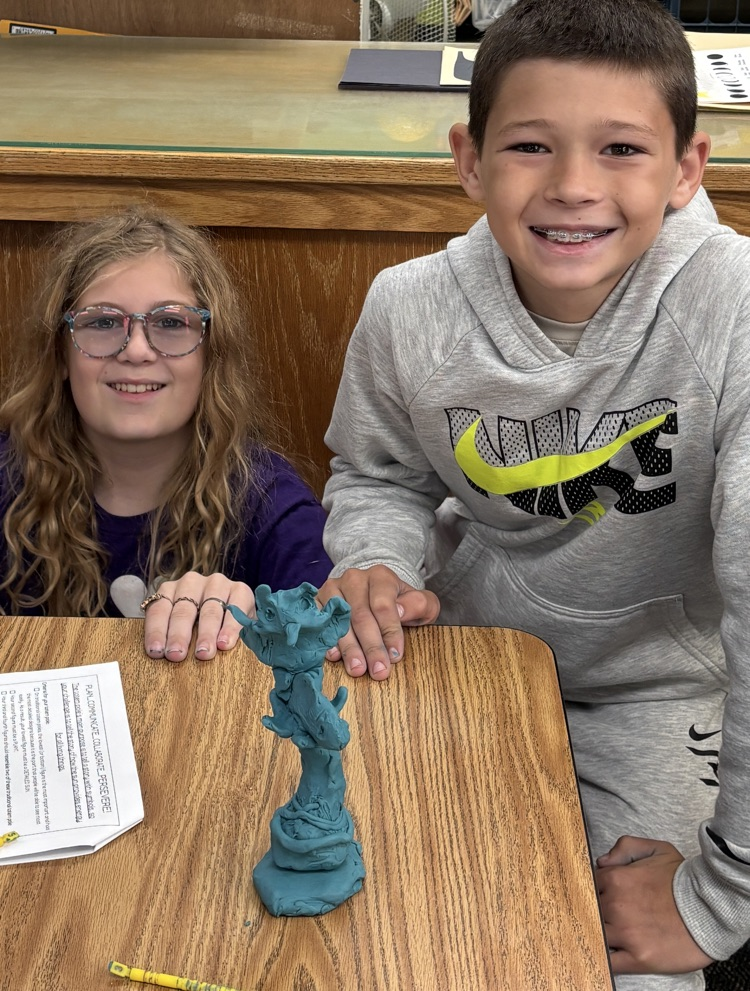 students with totem pole sculpture 