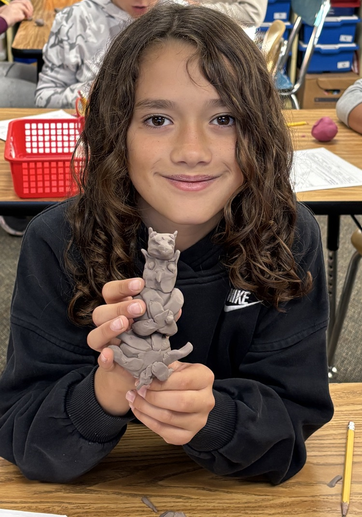 student with totem pole sculpture 