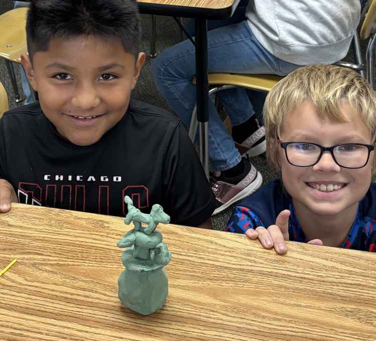 students with totem pole sculpture 