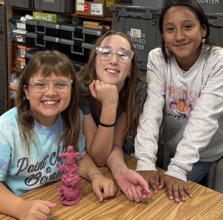students with totem pole sculpture 