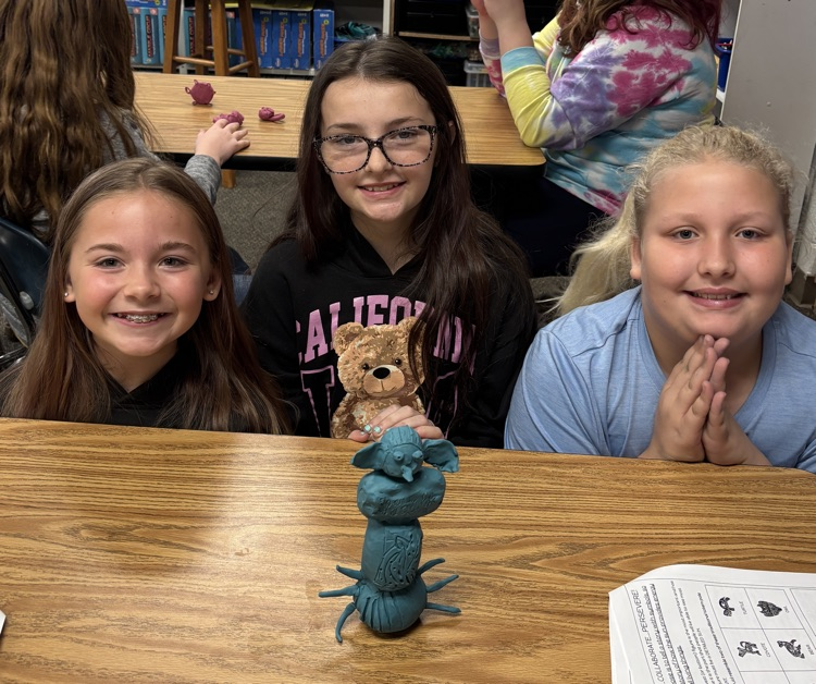 students with totem pole sculpture 