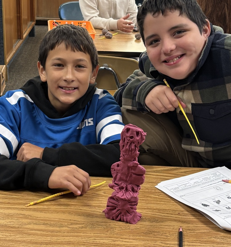 students with totem pole sculpture 