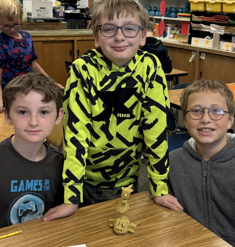 students with totem pole sculpture 