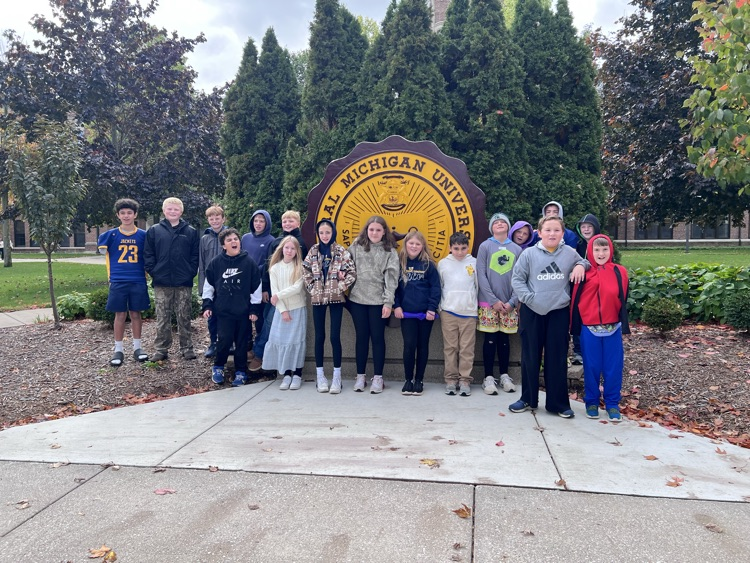 students in front of the CMU logo