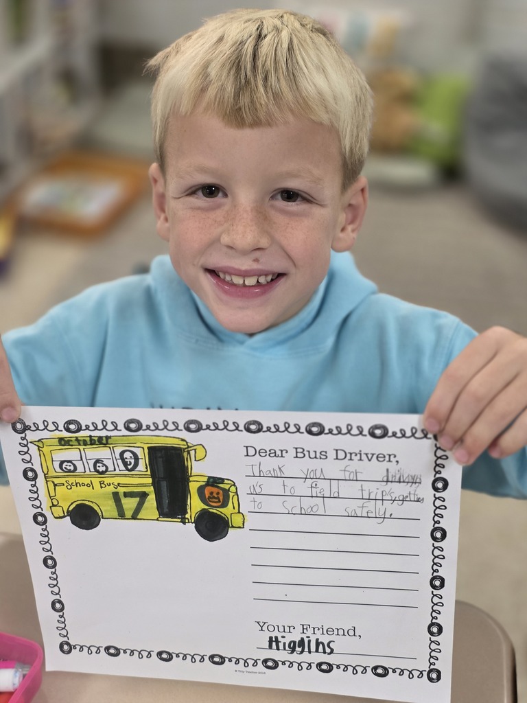 Student holding a letter to a bus driver.
