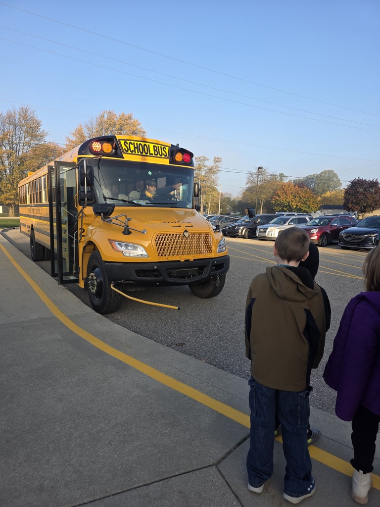 Students looking at a yellow school bus.