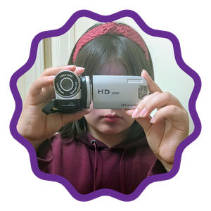 Picture of student in a red headband holding a video camera in front of their face