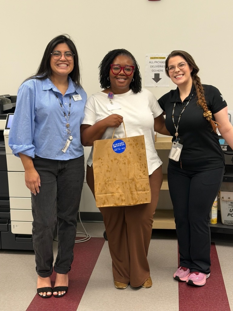 Photo of three women, middle is holding a bag from Eyemart Express