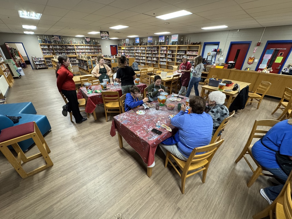 Families painting in a family paint night hosted by Partners for Rural Impact.