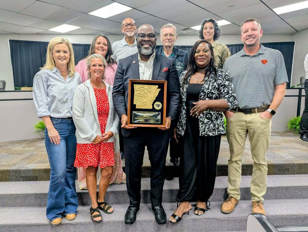 Group photo of JNPSD Superintendent Dr. Jeremy Owoh holding his 2027 Arkansas Superintendent of the Year award while standing with supporters and education leaders following the recognition.