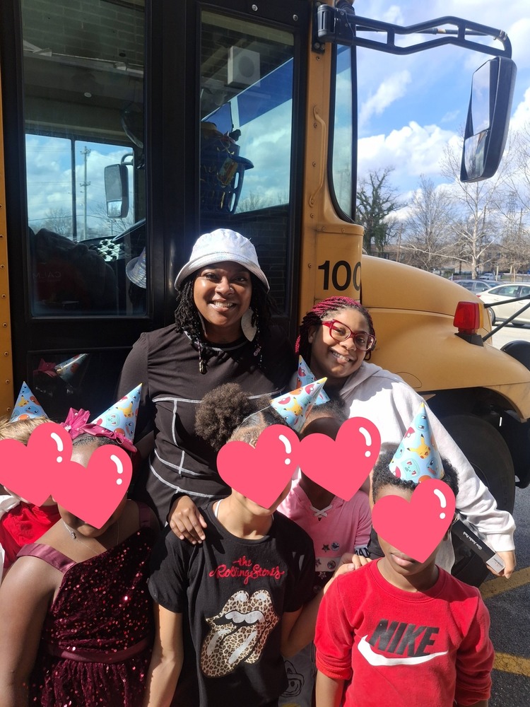 Two adults pose for a picture with five students.
