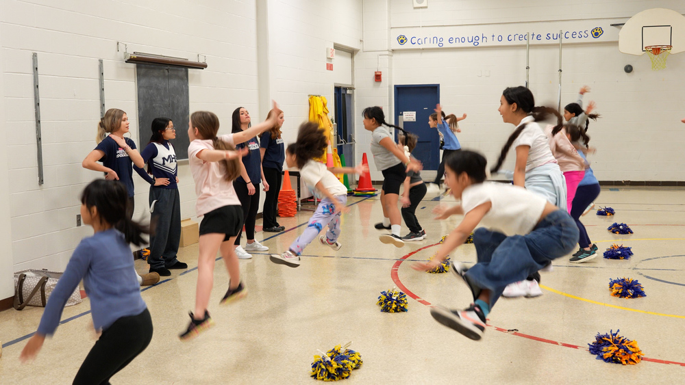 Girls jumping in a elementary school gymnasium