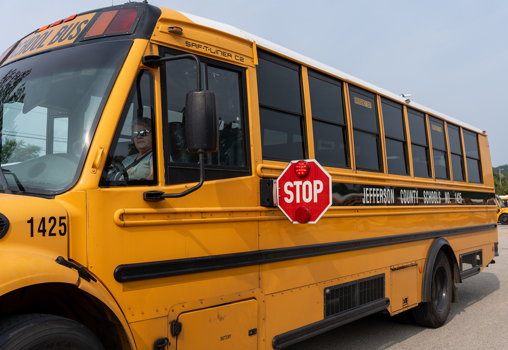A school bus extends its stop sign.