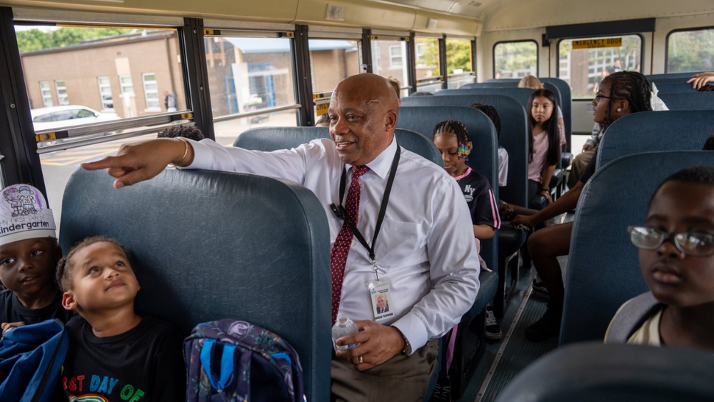 Dr. Yearwood and students on a school bus.