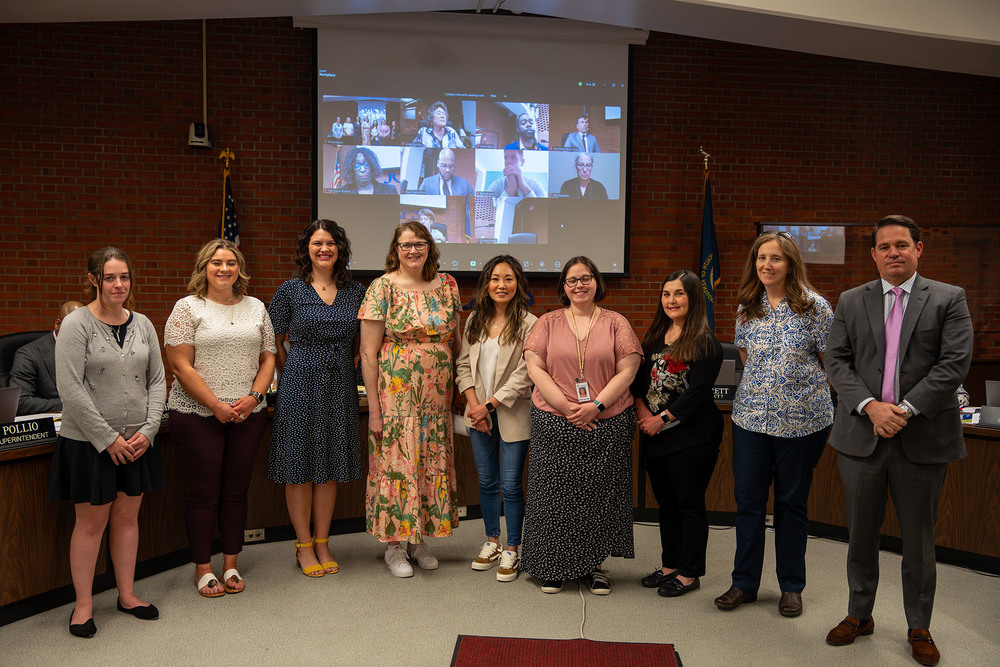Eight female educators pose for a picture with Superintendent Dr. Marty Pollio during a Board of Education meeting.