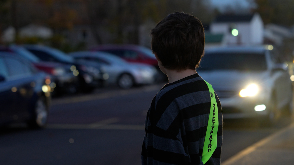 Kid looking at a car driving up