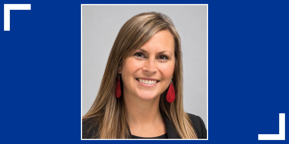 Portrait of Erin Basham, newly appointed principal of Chenoweth Elementary, smiling in front of a neutral grey background.