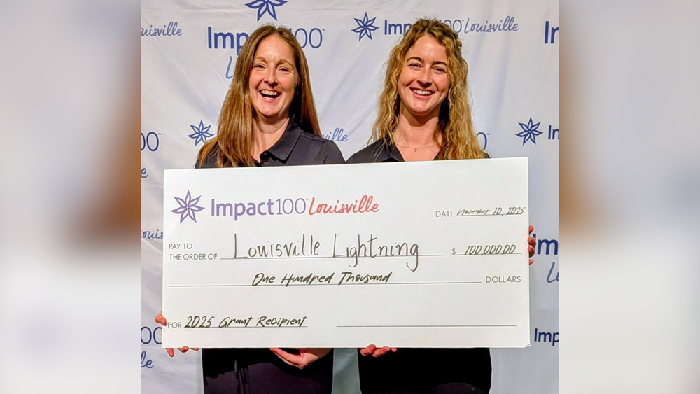 Two women holding a check that says "Louisville Lightning" one-hundred thousand dollars from Impact100 Louisvile