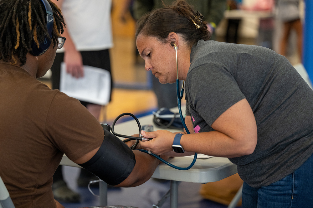 A nurse takes blood pressure of a student.