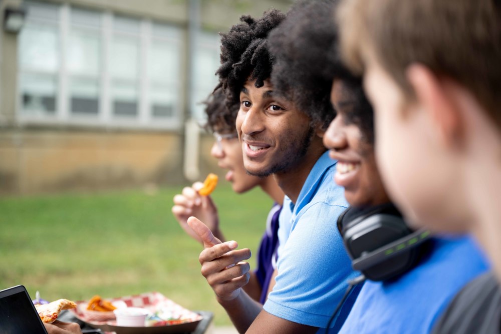 Students talking at lunch, outdoors.