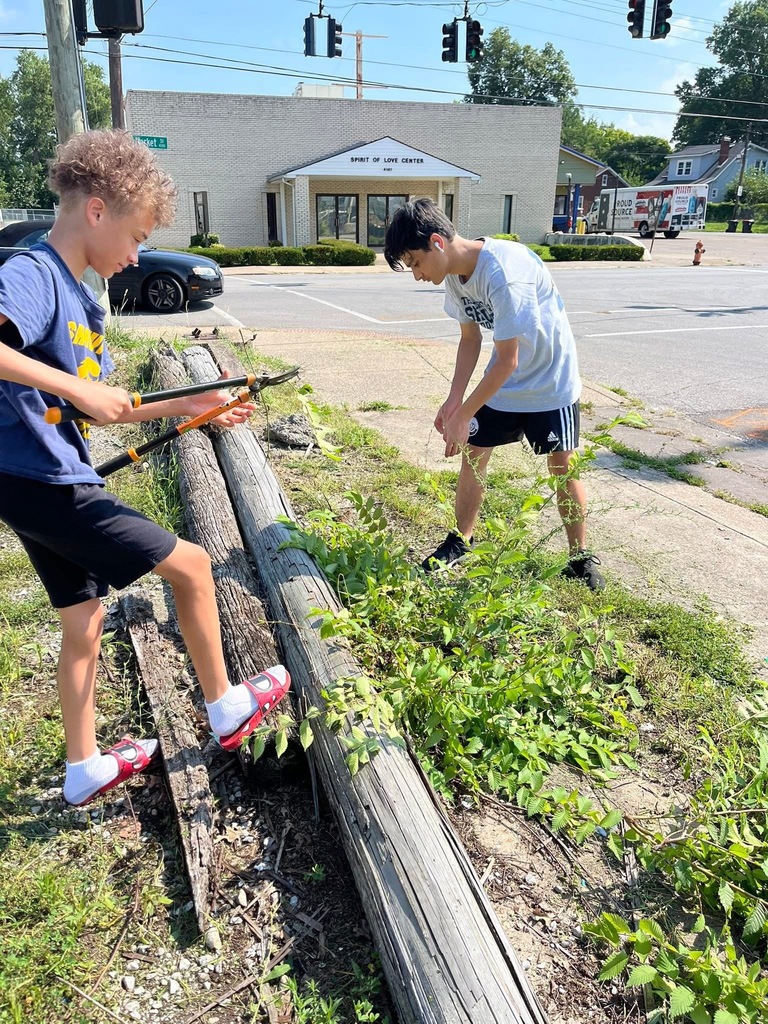 Two students do yard work.