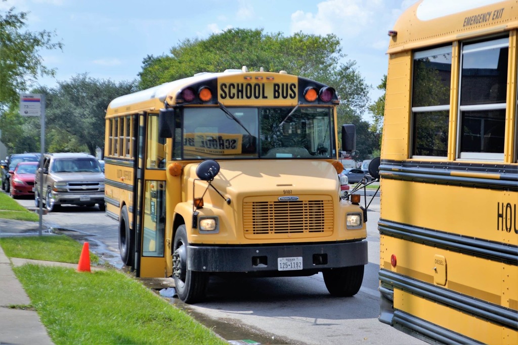 buses and cars waiting at a school