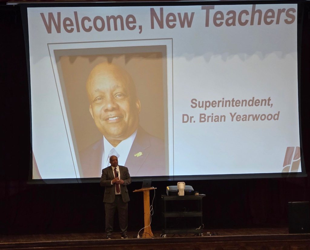 Dr. Yearwood stands on a stage and speaks at a JCPS 101 event.