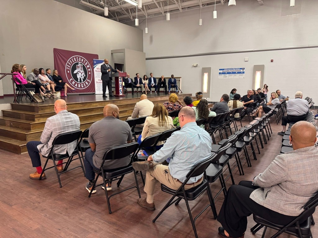 Community members sit in the audience as Dr. Brian Yearwood and other district leaders are on stage during a Community Conversation event.