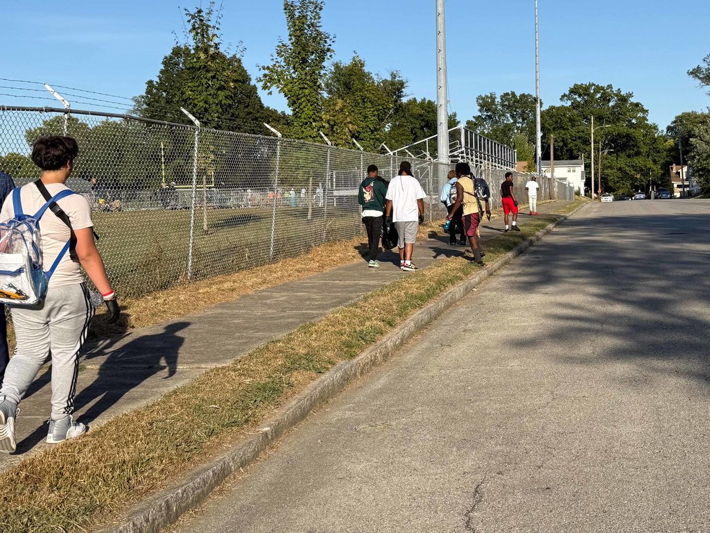 Students walk down a sidewalk.