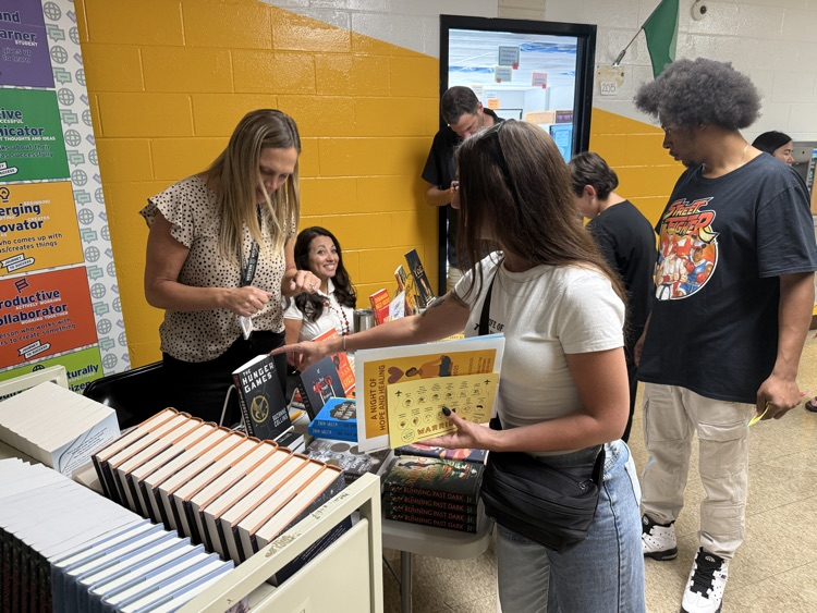 Students at the literacy table receiving free young adult novels