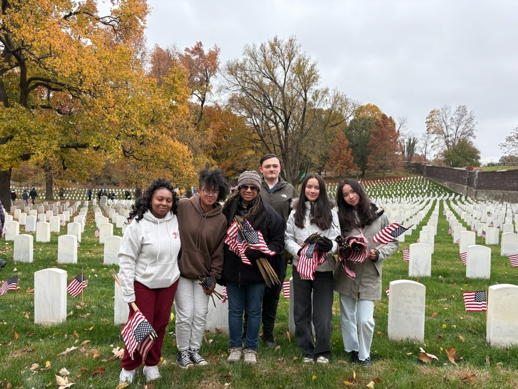 Students pose for a picture holding flags.