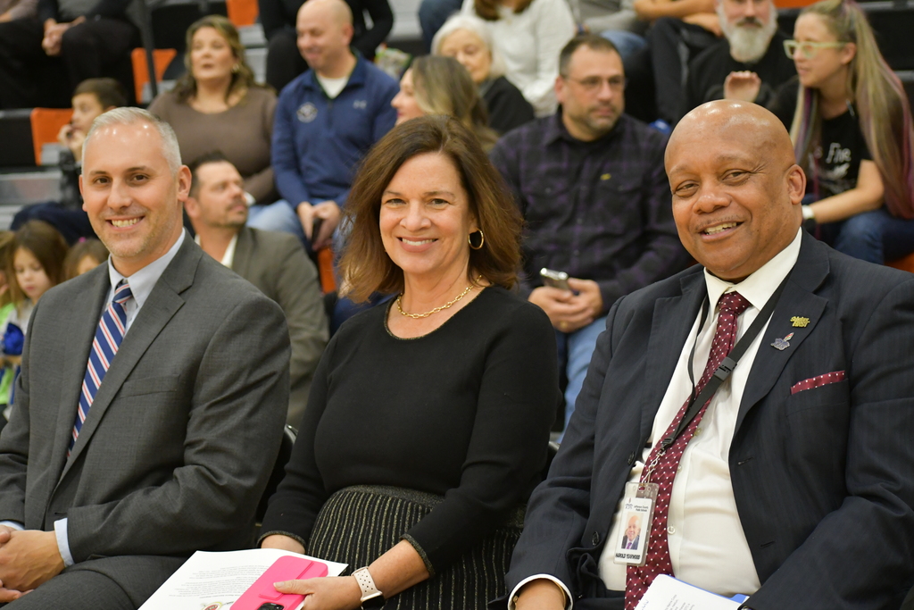 Three adults pose for a picture.