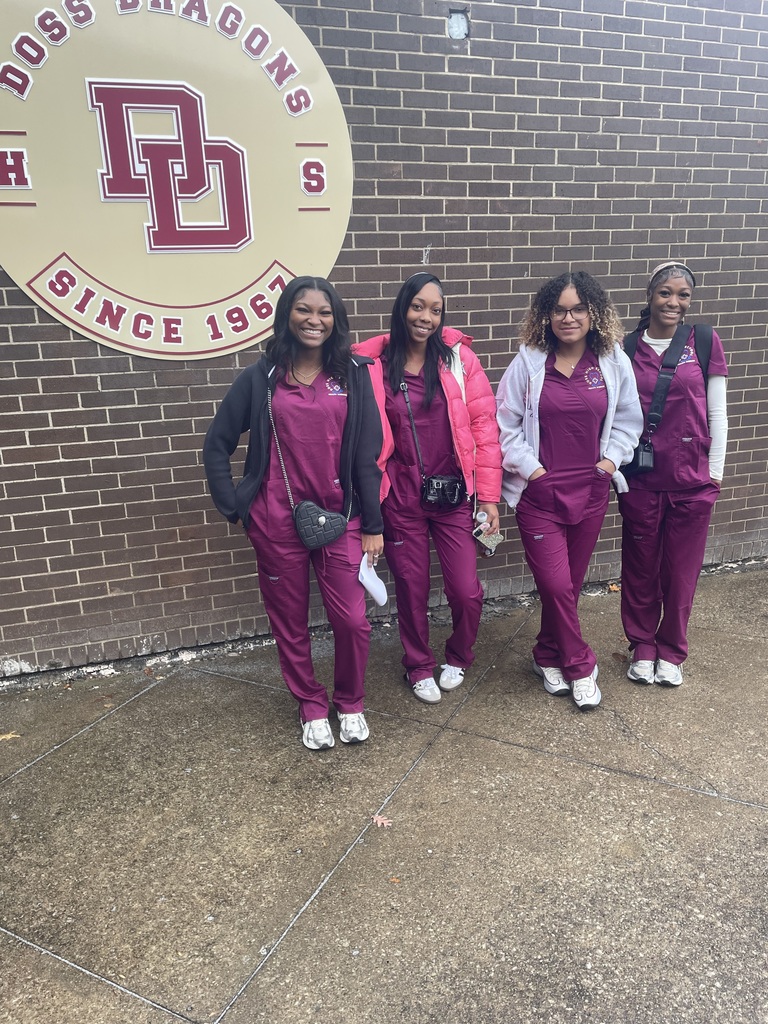 4 students in scrubs with doss logo