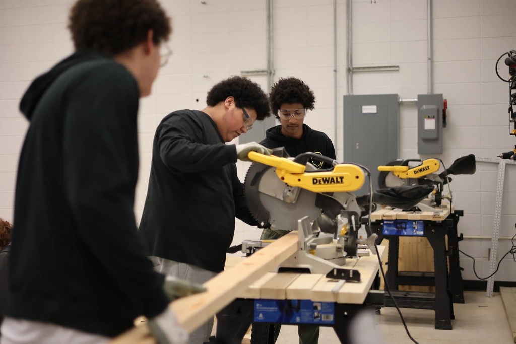 A student operates a table saw.