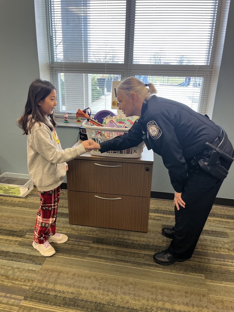 A police officer shakes hands with a student.