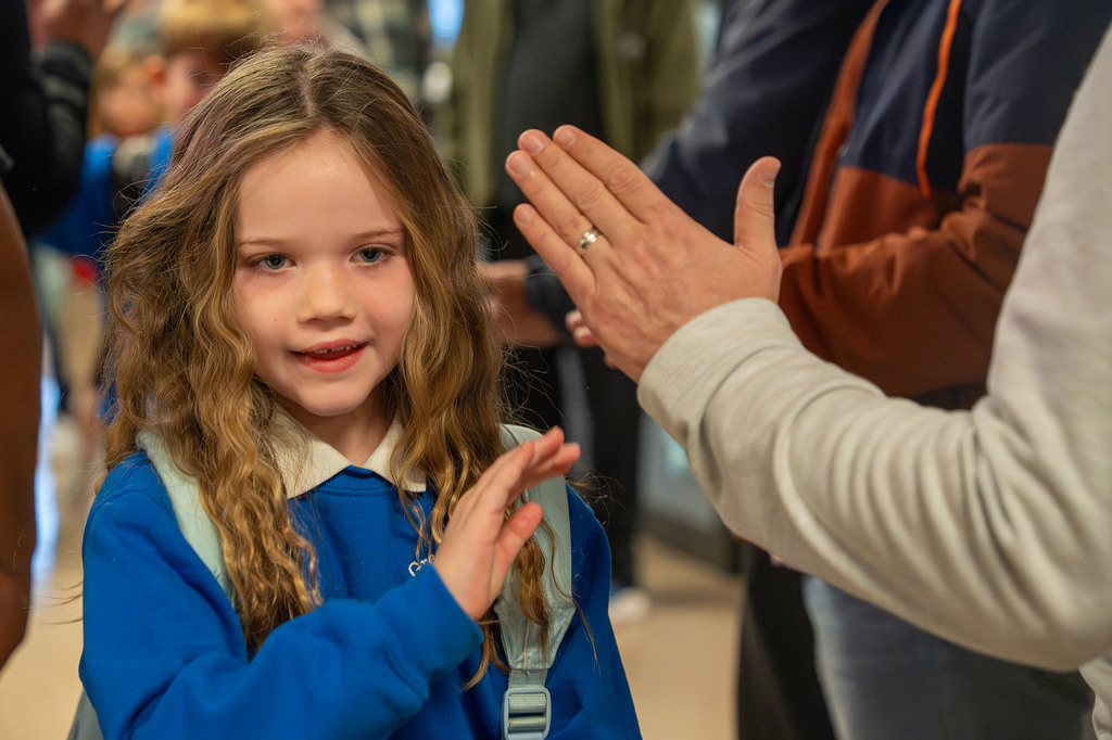 A student high-fives a JCPS Flash Dad.