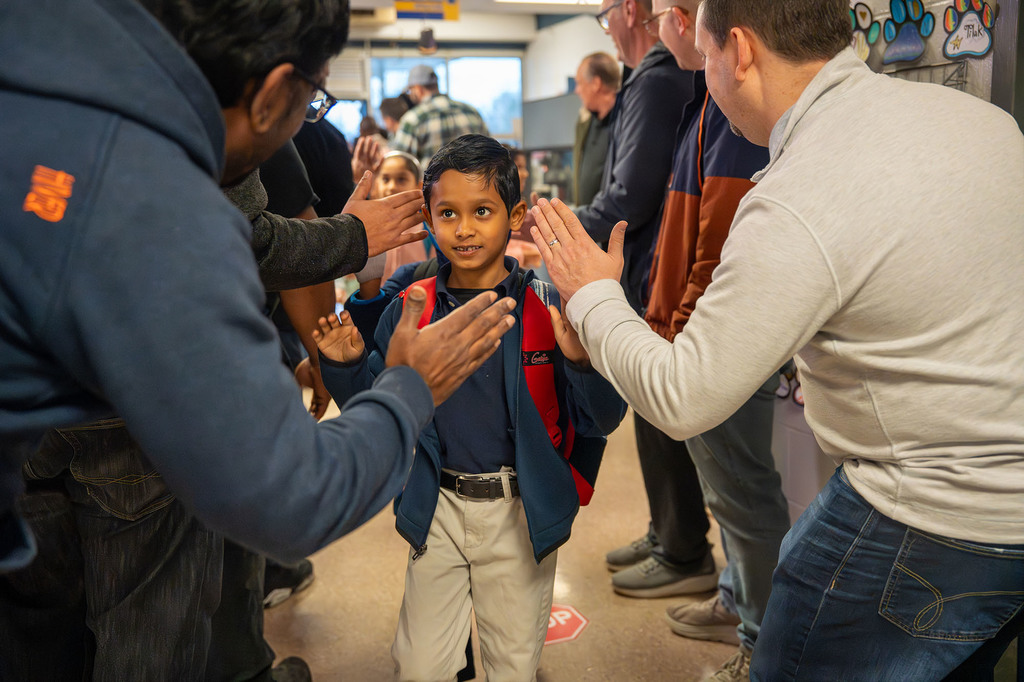 A student high-fives a JCPS Flash Dad.