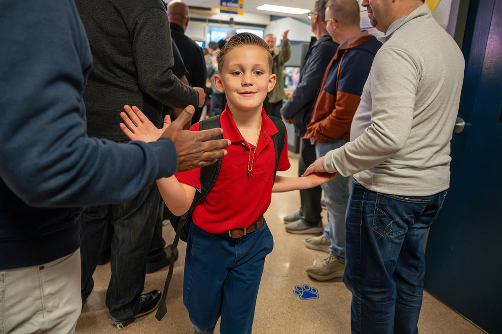 A student high-fives a JCPS Flash Dad.