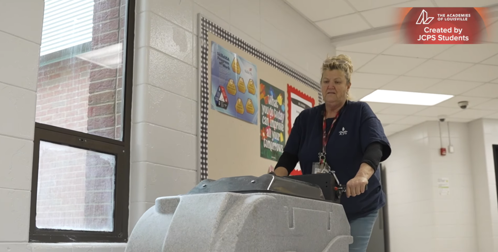 A plant operator operates a floor cleaner.