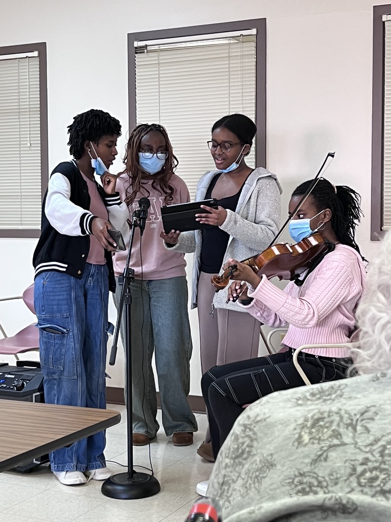 Students sing and play instruments.