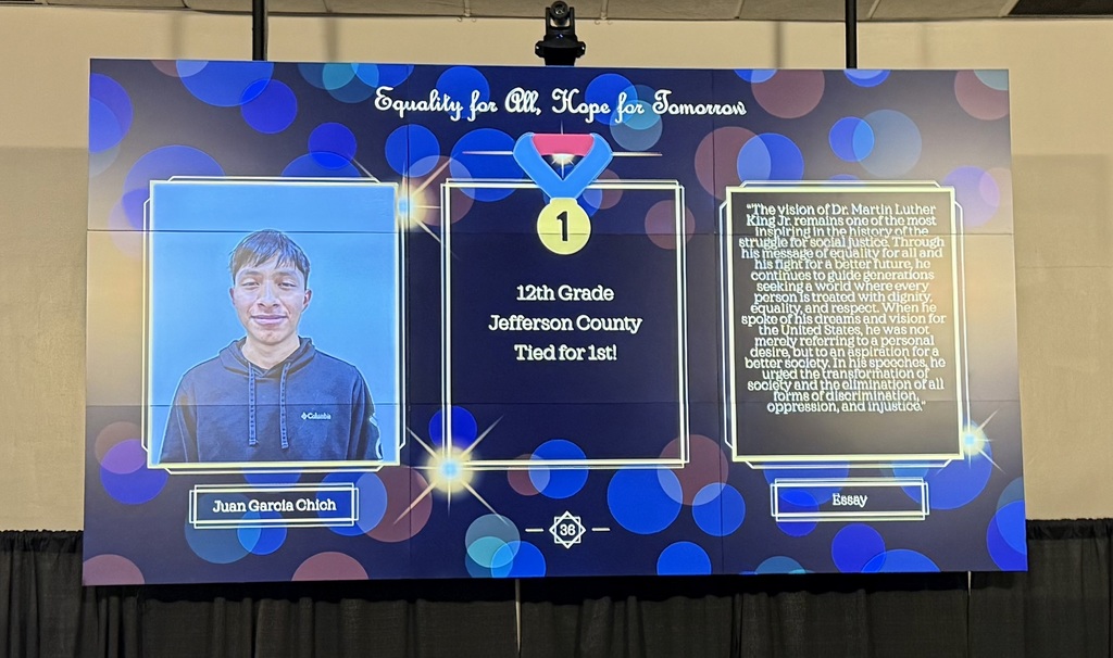 A presentation displays on a large screen during an awards ceremony.