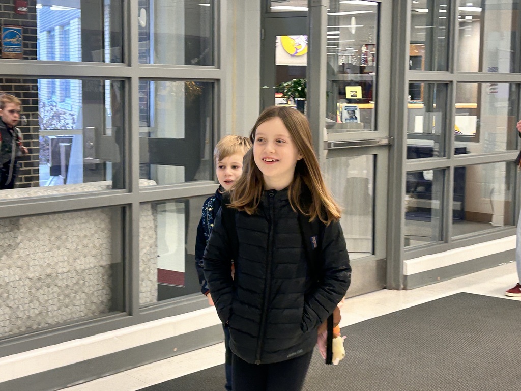 Students smile in the hallway.