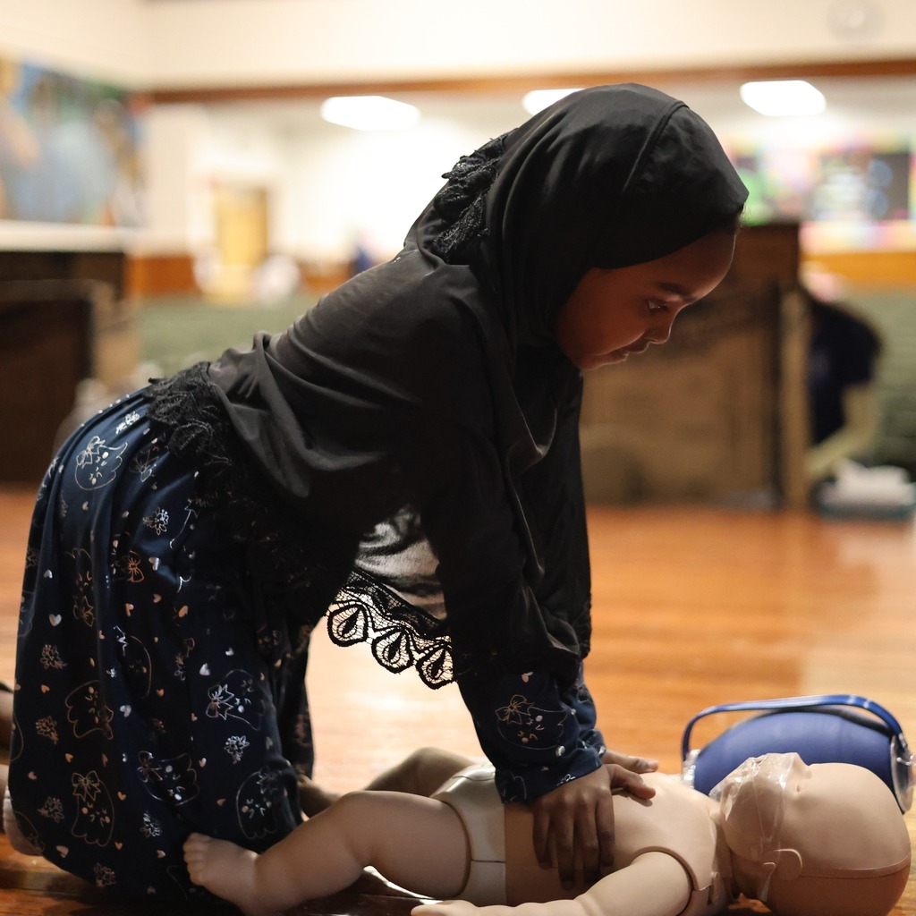 A student does CPR on a mannequin.