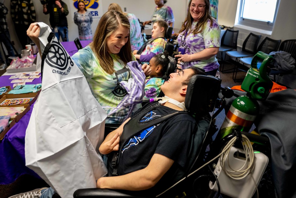Woman holding Churchill Perk Apron with student, smiling