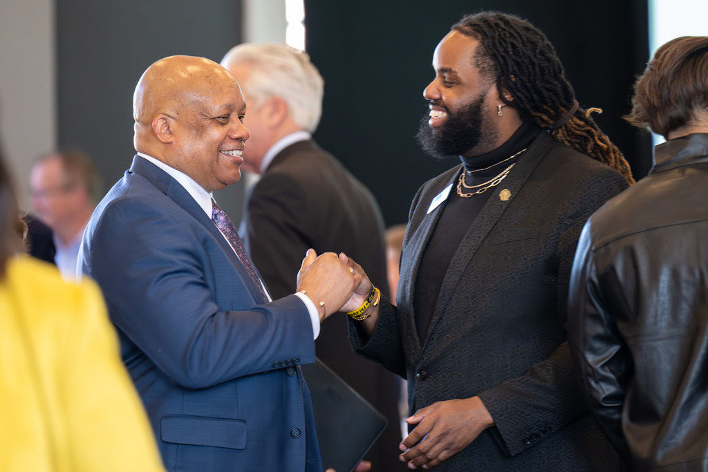 Dr. Yearwood shakes hands with an adult.