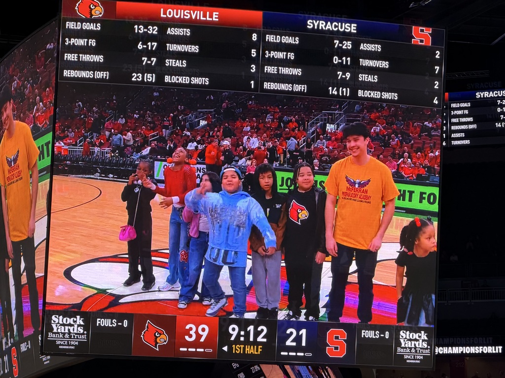Students and adults stand on the court at the KFC Yum! Center.
